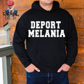 Person wearing a black hoodie with 'DEPORT MELANIA' text against a wooden background.